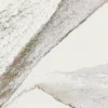 Close-up view of rich brown currents flowing against a crisp white background, accented by subtle flashes of radiant brass in Cambria Windsor Brass Quartz design